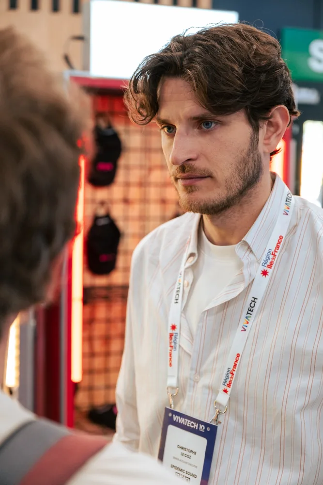 Un collaborateur d'Epidemic Sound à l'écoute d'un visiteur sur le stand