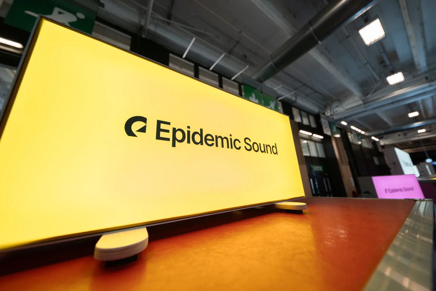 Enseigne lumineuse Epidemic Sound sur le stand, dans l'allée du salon