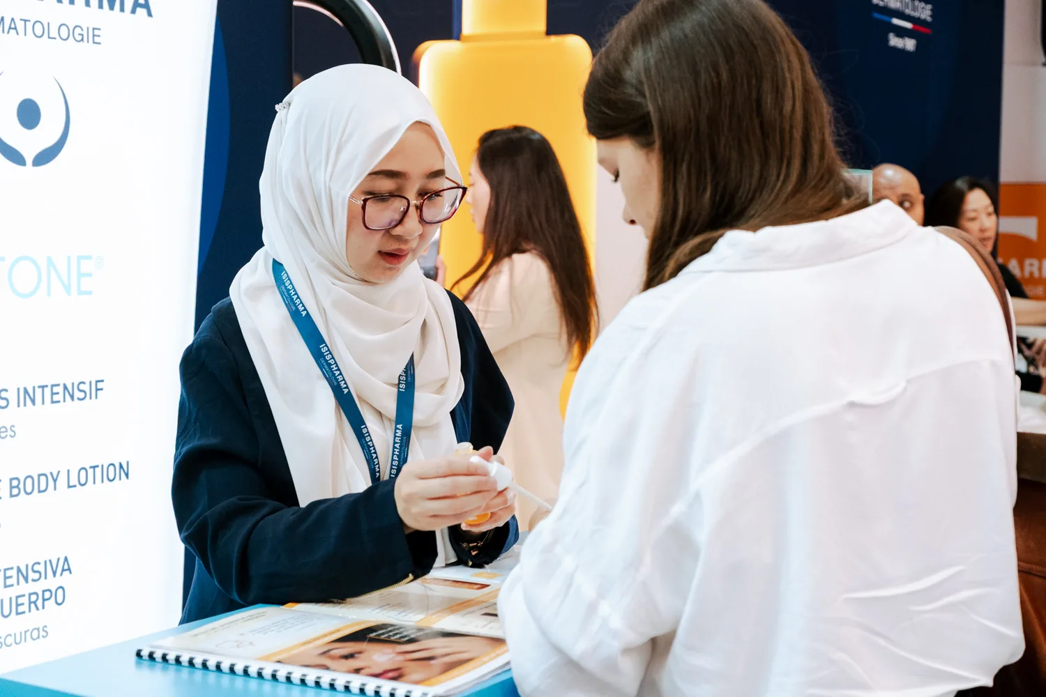 Conseillère Isispharma présentant un produit à une visiteuse sur le stand